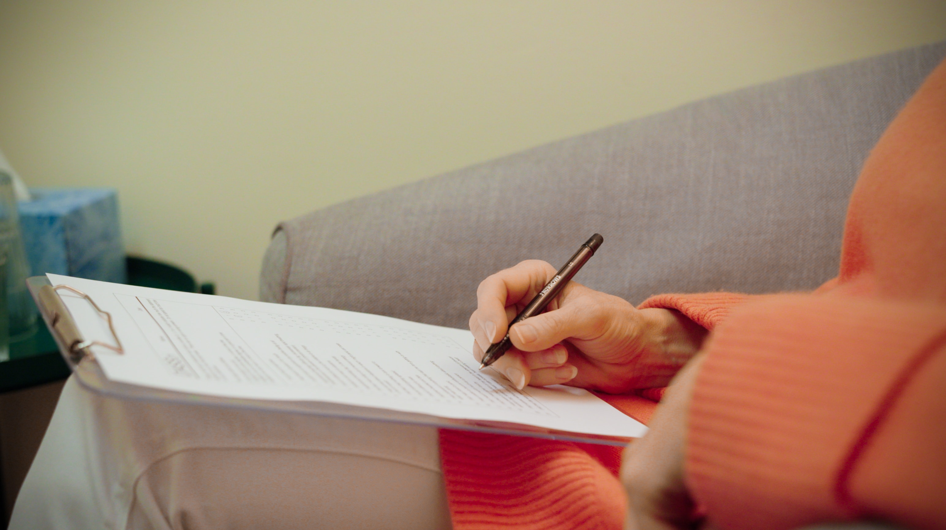 Client completing intake paperwork during a therapy session